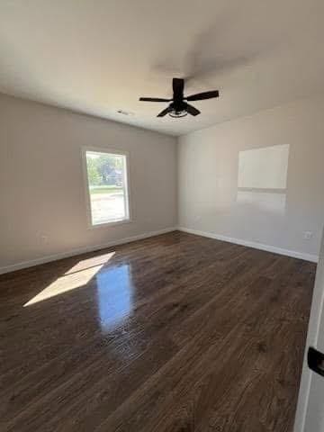 empty room featuring ceiling fan and dark wood-type flooring