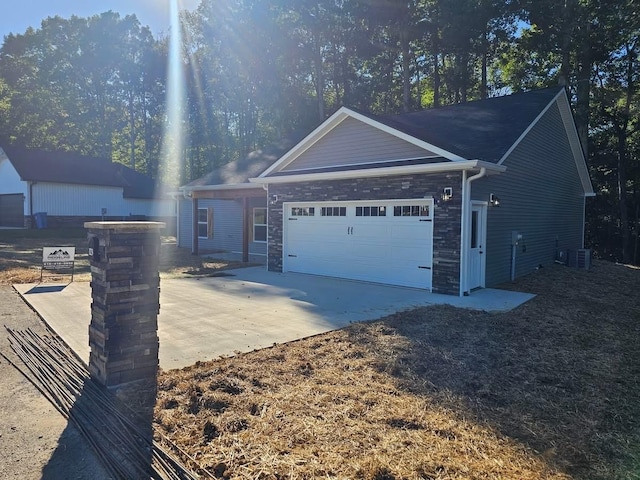 view of front of property featuring a garage and cooling unit