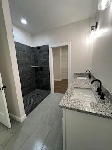 bathroom featuring vanity and tiled shower