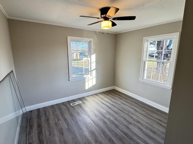 empty room with dark hardwood / wood-style floors, ceiling fan, crown molding, and a textured ceiling