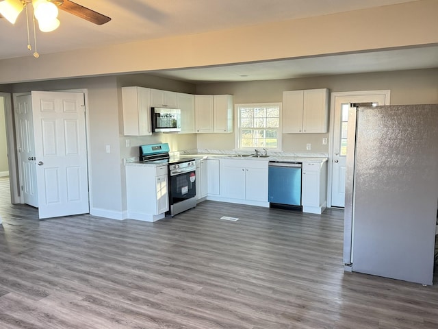 kitchen featuring white cabinets, sink, ceiling fan, dark hardwood / wood-style flooring, and stainless steel appliances