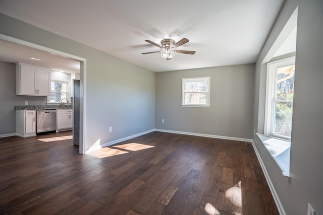 unfurnished room featuring dark hardwood / wood-style flooring, ceiling fan, and sink