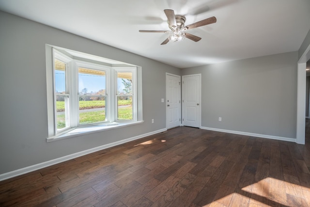 spare room featuring ceiling fan and dark wood-type flooring