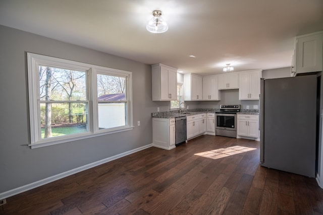 kitchen featuring dark hardwood / wood-style flooring, white cabinetry, sink, and appliances with stainless steel finishes