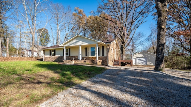 view of front of home with a porch, a garage, an outbuilding, and a front lawn