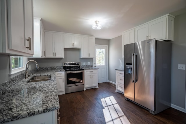 kitchen featuring white cabinets, stainless steel appliances, light stone counters, and sink