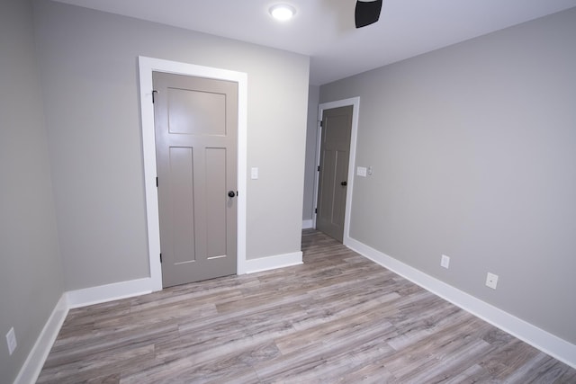 unfurnished bedroom with ceiling fan and light wood-type flooring