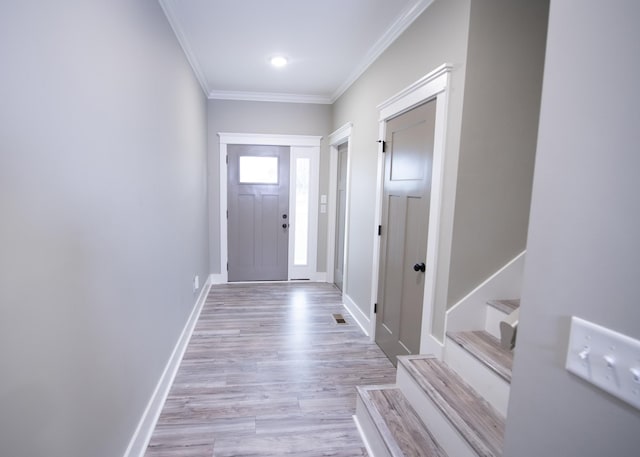 doorway to outside with light wood-type flooring and crown molding