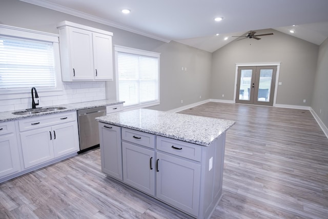 kitchen with sink, french doors, stainless steel dishwasher, backsplash, and a kitchen island