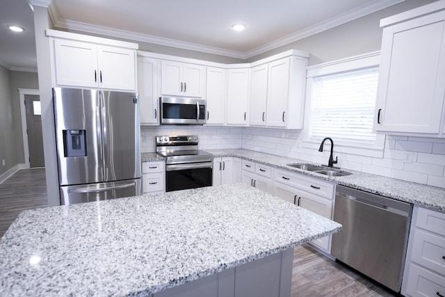 kitchen with white cabinets, sink, decorative backsplash, light stone countertops, and stainless steel appliances