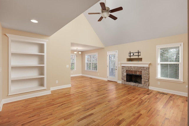 unfurnished living room with a fireplace, built in features, light hardwood / wood-style floors, and ceiling fan with notable chandelier