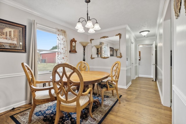 dining area featuring light hardwood / wood-style floors, crown molding, a wealth of natural light, and a chandelier