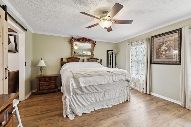 bedroom featuring crown molding, ceiling fan, a barn door, a textured ceiling, and wood-type flooring