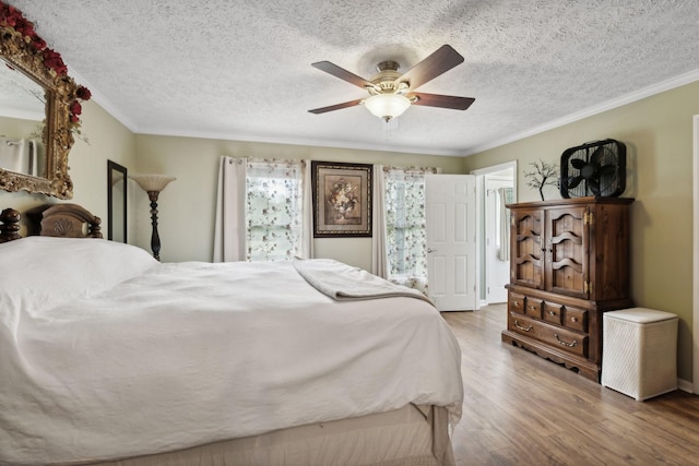 bedroom with wood-type flooring, a textured ceiling, ceiling fan, and ornamental molding