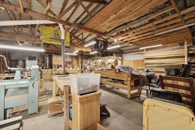 miscellaneous room featuring a workshop area, concrete flooring, and vaulted ceiling