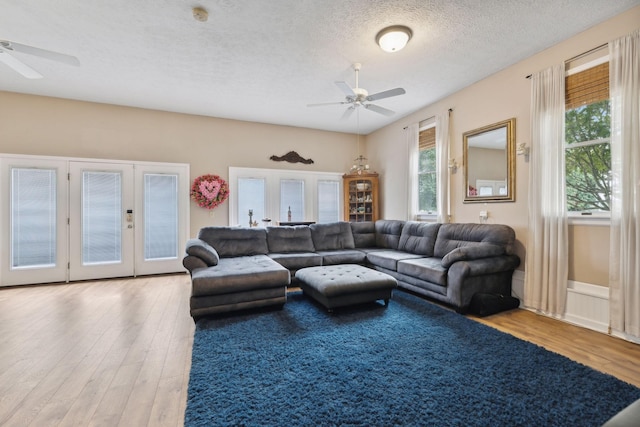 living room featuring french doors, hardwood / wood-style floors, a textured ceiling, and ceiling fan