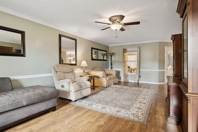 living room featuring ceiling fan, ornamental molding, a textured ceiling, and hardwood / wood-style flooring