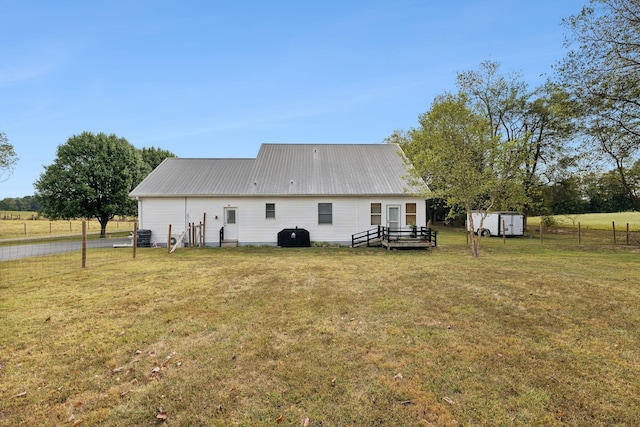 rear view of property with a yard and central AC