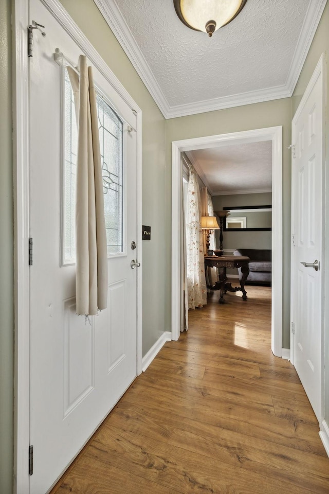 foyer entrance featuring hardwood / wood-style flooring, crown molding, and a textured ceiling