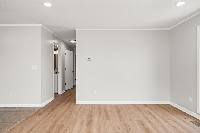 unfurnished room featuring crown molding and light wood-type flooring