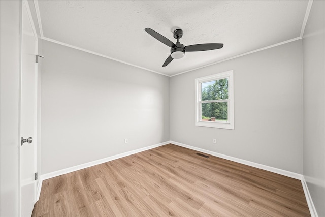 empty room featuring ceiling fan, light hardwood / wood-style floors, and crown molding