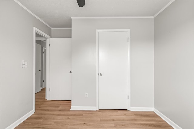 unfurnished bedroom with a closet, light hardwood / wood-style flooring, ceiling fan, and ornamental molding