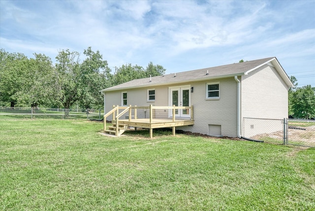 rear view of house with french doors, a yard, and a deck