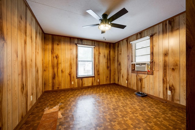 spare room featuring dark parquet flooring, ceiling fan, cooling unit, and a healthy amount of sunlight