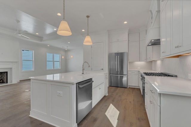 kitchen featuring custom range hood, appliances with stainless steel finishes, open floor plan, light countertops, and light wood-style floors