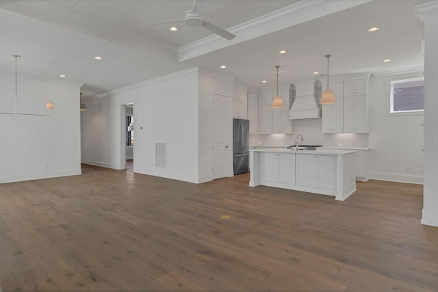 kitchen with a ceiling fan, open floor plan, high quality fridge, a sink, and premium range hood