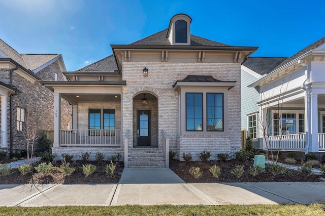 view of front of home with covered porch and brick siding