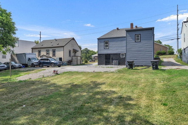 rear view of house with a yard and central air condition unit