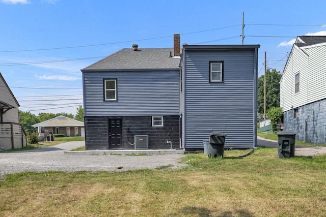 back of house featuring a yard and central AC unit