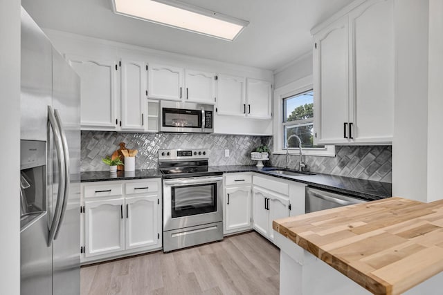 kitchen featuring tasteful backsplash, white cabinetry, sink, and appliances with stainless steel finishes