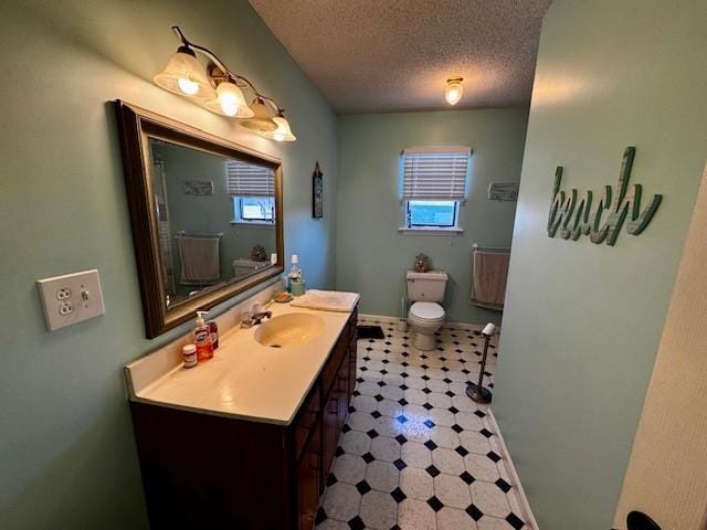 bathroom with vanity, a textured ceiling, and toilet