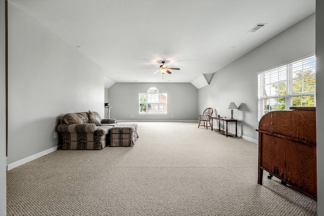 living area featuring ceiling fan, light colored carpet, and vaulted ceiling