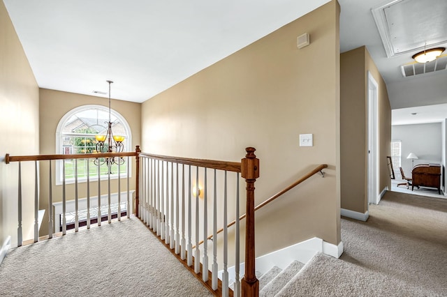 hall with carpet flooring and a notable chandelier