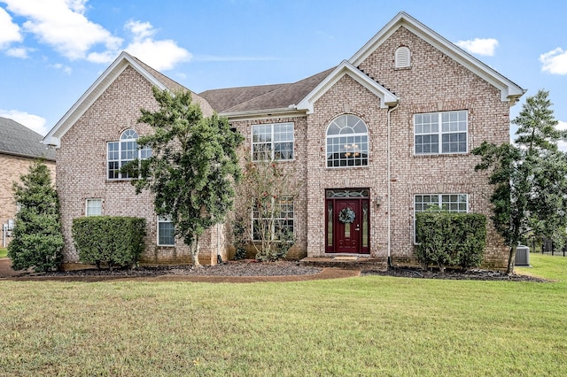 front facade featuring central AC and a front lawn