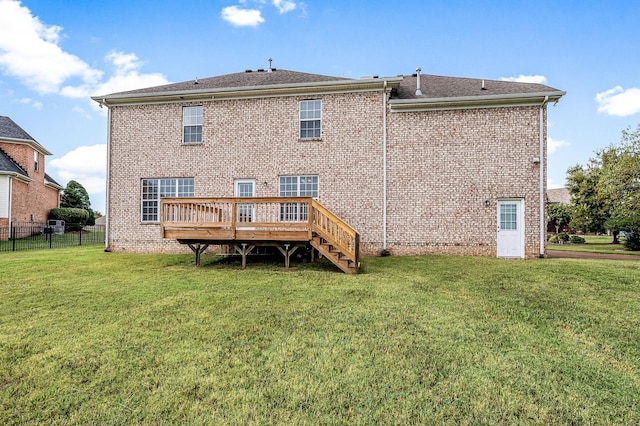 rear view of property featuring a yard and a wooden deck