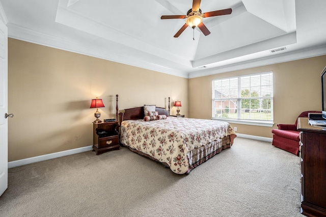 bedroom featuring a raised ceiling, ceiling fan, crown molding, and light carpet