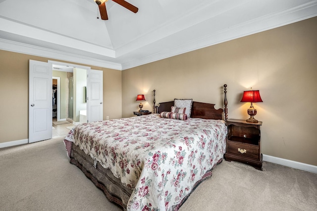 carpeted bedroom with a tray ceiling, ceiling fan, ensuite bathroom, and ornamental molding