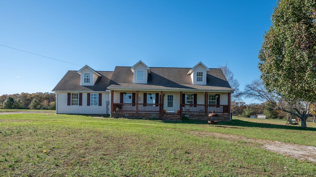 new england style home with a porch and a front lawn