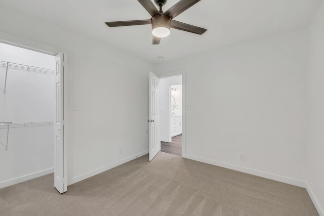 unfurnished bedroom featuring light carpet, a closet, and ceiling fan