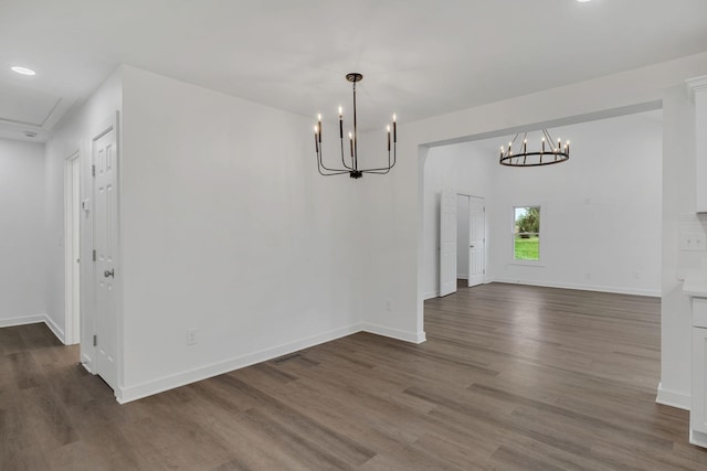 unfurnished dining area with dark hardwood / wood-style floors and an inviting chandelier