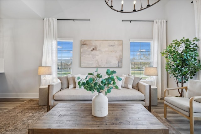 living room with dark hardwood / wood-style floors and an inviting chandelier