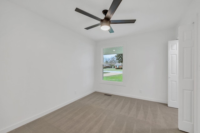 spare room with light colored carpet and ceiling fan