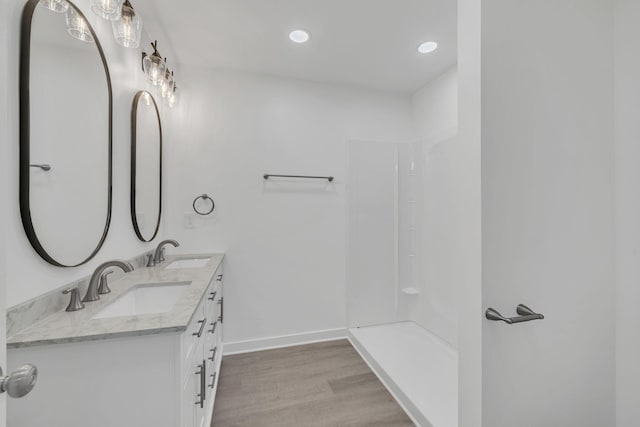 bathroom featuring vanity, hardwood / wood-style flooring, and walk in shower