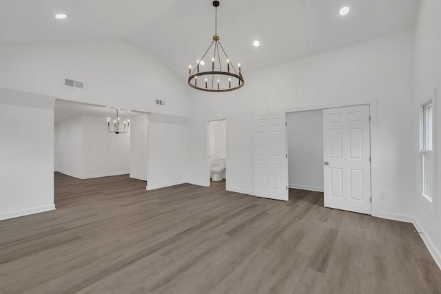 interior space featuring wood-type flooring, high vaulted ceiling, and a chandelier