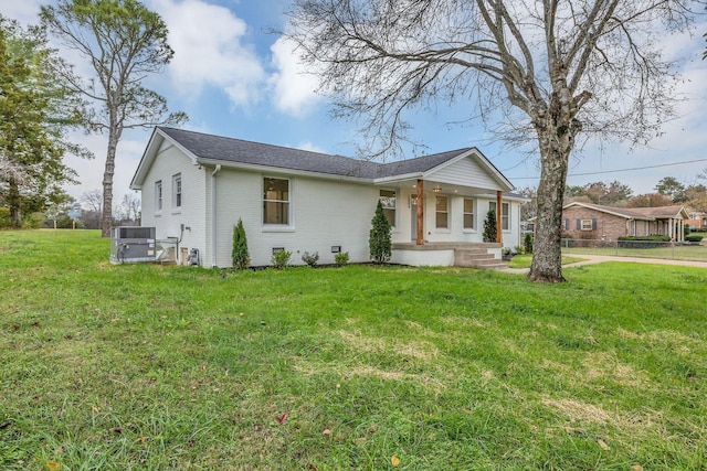 ranch-style house featuring covered porch, central air condition unit, and a front yard