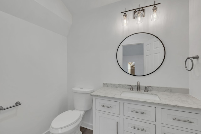 bathroom featuring vanity, vaulted ceiling, and toilet